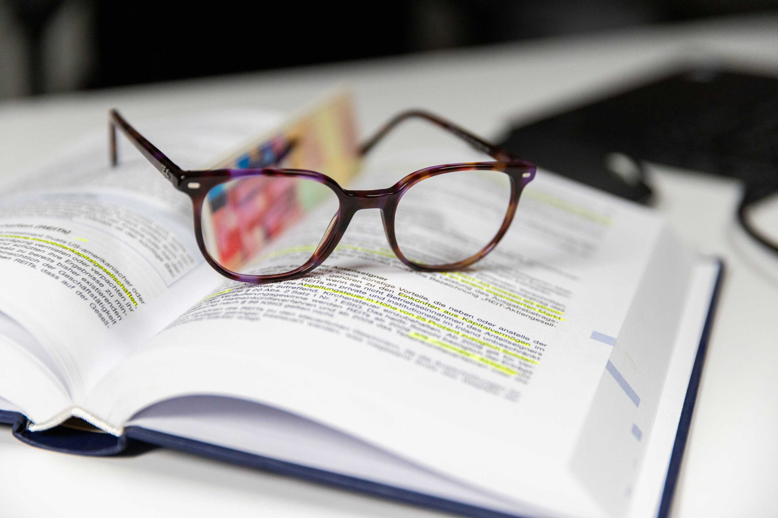 Katrin Pingel professionelle Coachin für Finanzen und Vorsorge aus Unna. Eine Brille liegt auf einem offenen Buch mit markiertem Text. Das Bild dient zur Illustration der Zitat-Box auf der Workshops & Vorträge zum Thema: „Investiere in Dich selbst. Es zahlt die besten Zinsen..“